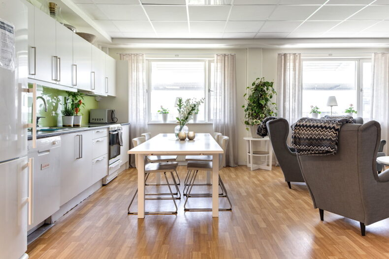 Vitt kök med ljusgrönt kakel och matbord