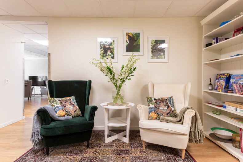 Mycket dekorativ läshörna, fåtöljer med plädar och kuddar. Bokhylla med flertal spel vid sidan