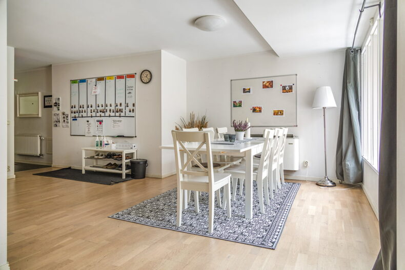 Boendets gemensamma matplats. I bakgrunden sitter whiteboard-tavlor med veckoscheman och annat kognitivt stöd