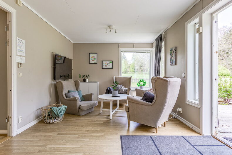 En gemensam TV-hörna med fåtöljer och soffbord