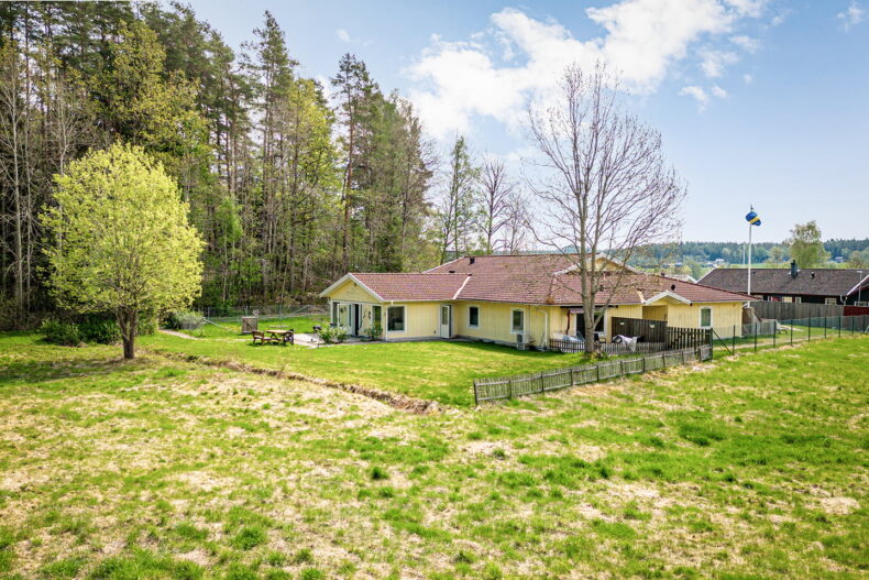 Boendet sett från närliggande fält med skog i bakgrunden