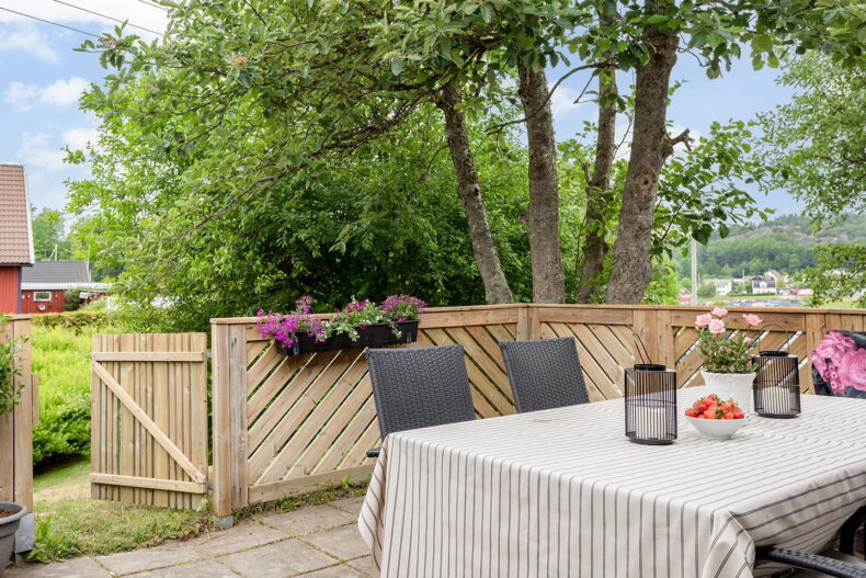 En möblerad uteplats omgiven av grönska