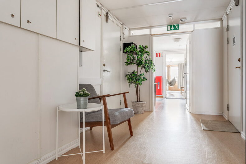 Ljus korridor med sittplats, förvaring och växter