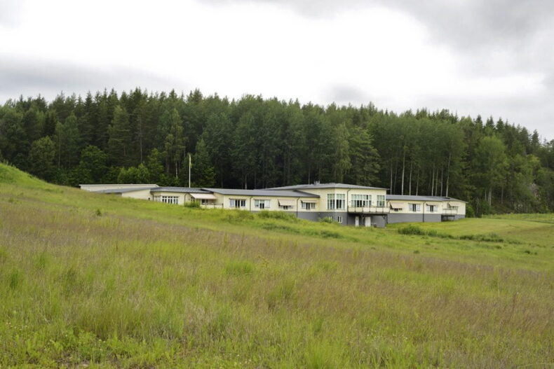 Boendet sett på håll med gräsmarker i förgrunden