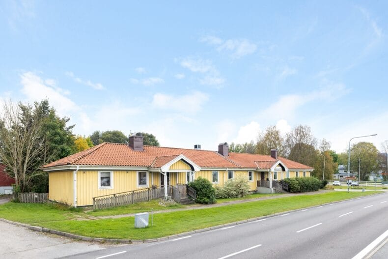 Verksamhetens gula enplansbyggnad sedd från bilvägen