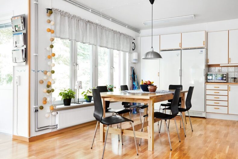 Matplatsen i boendets gemensamma kök, med stora ljusa fönster till vänster