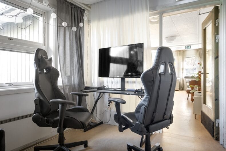 Ett skrivbord med en dator på och två ergonomiska datorstolar framför