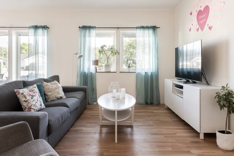 En soffa och en fåtölj framför en TV i boendets gemensamma del.