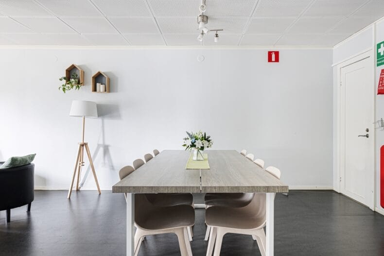 Matbord med åtta stolar och en liten blomsterdekoration mitt på