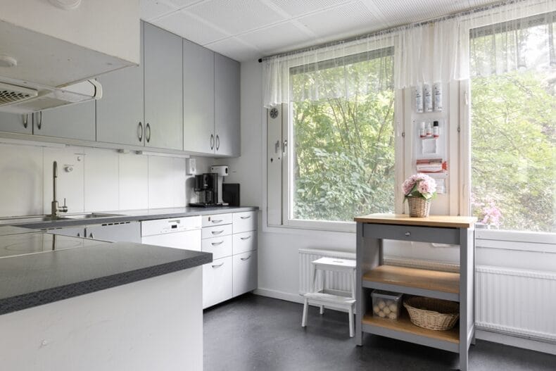 Boendets kök med stora fönster mot grönskande natur