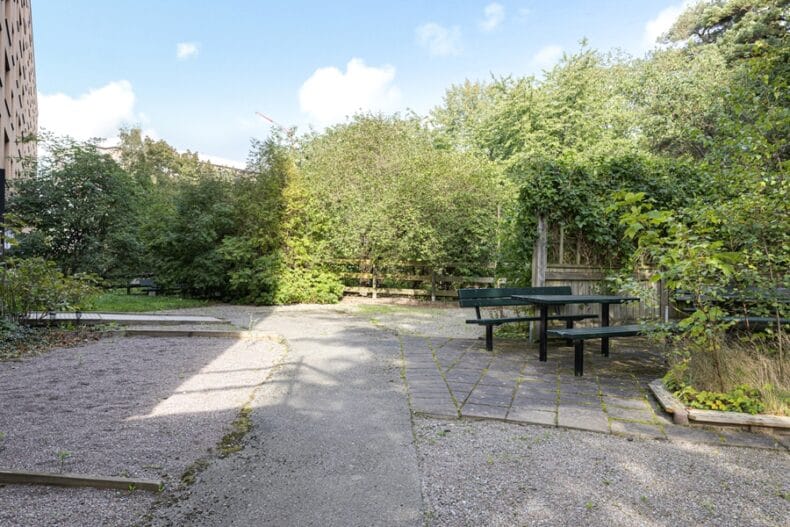 Innergård med sittplatser och mycket grönskande natur