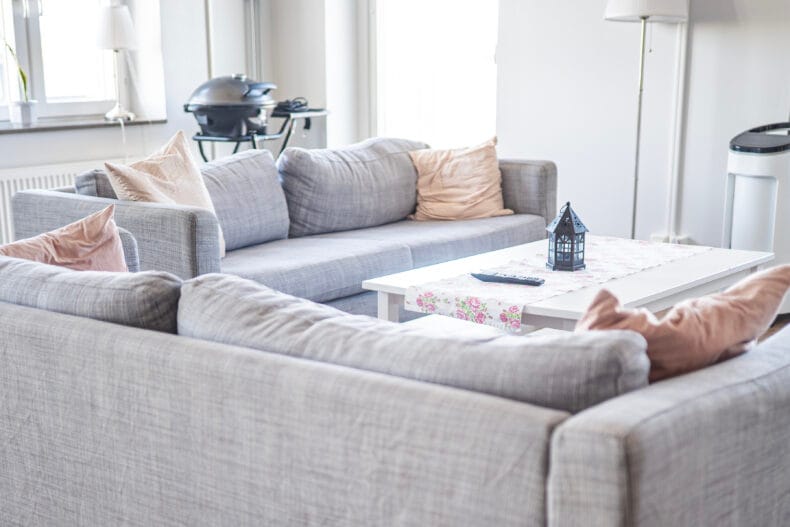 Två grå soffor och vitt soffbord i mysig miljö