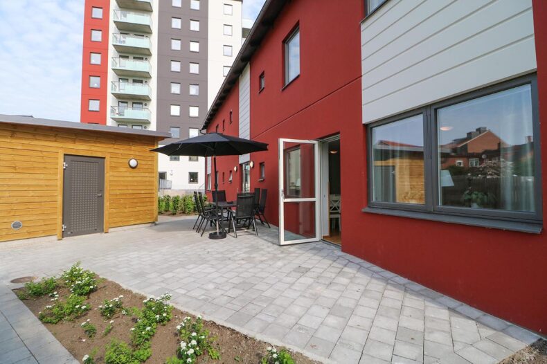 Boendets uteplats med en rabatt i förgrunden