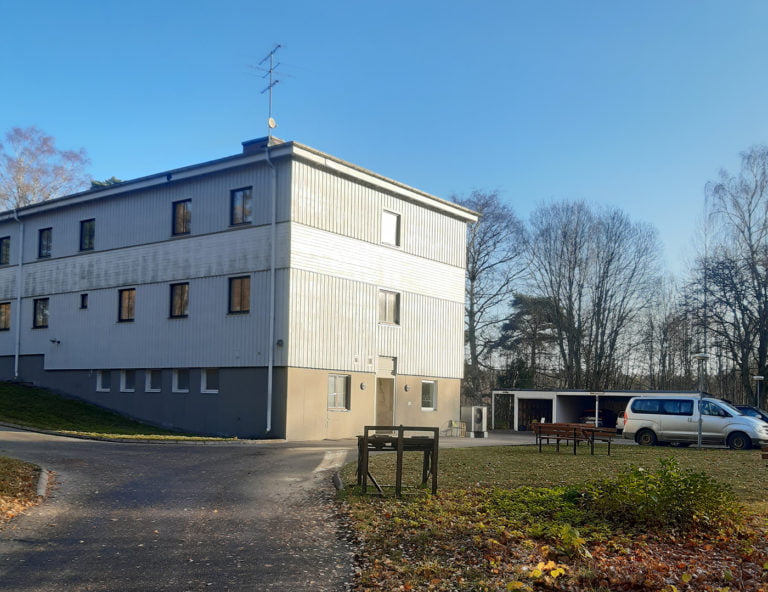 Verksamhetens fasad med parkering utanför