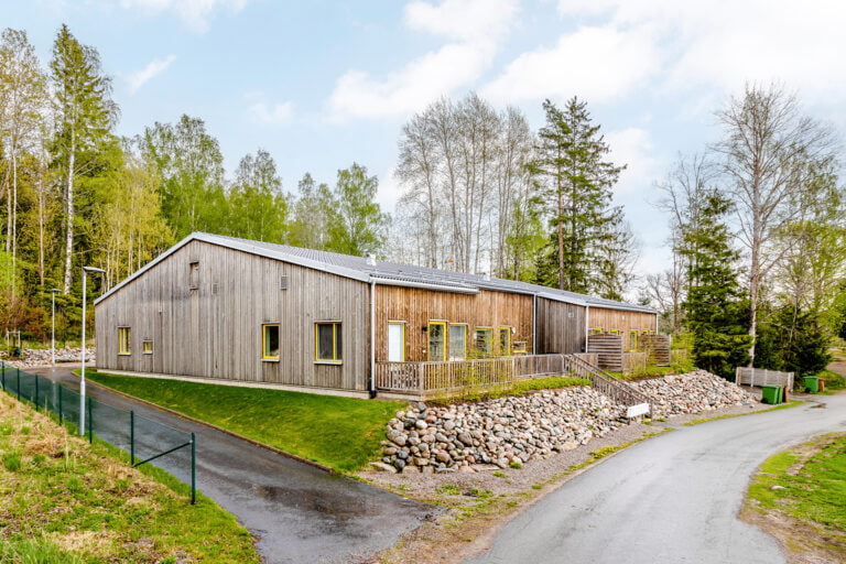 Boendets fasad, en träbyggnad i ett plan omgärdat av skog