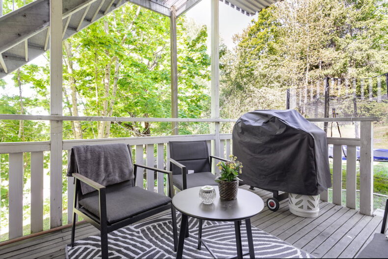 Uteplats med möbler och grill, en studsmatta nedanför