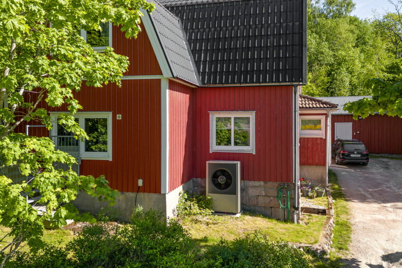 Boendets fasad, en röd villa omgiven av träd