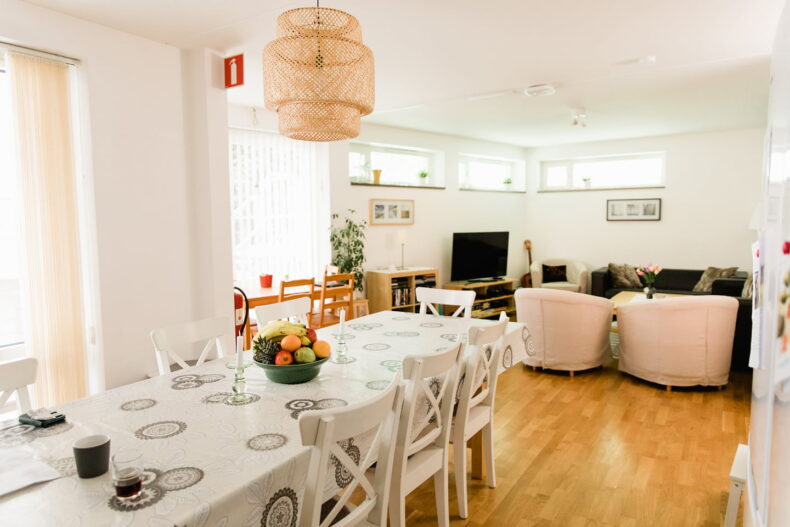 Stort rum med fint uppdukat långbord i förgrunden, TV-hörna i bakgrunden.