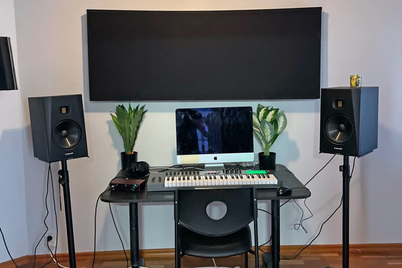 Boendets musikstudio med en synth och två högtalare vid en dator