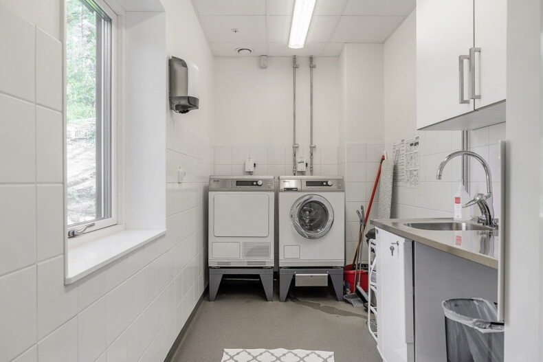Tvättstuga med tvättmaskin, torktumlare och en diskho