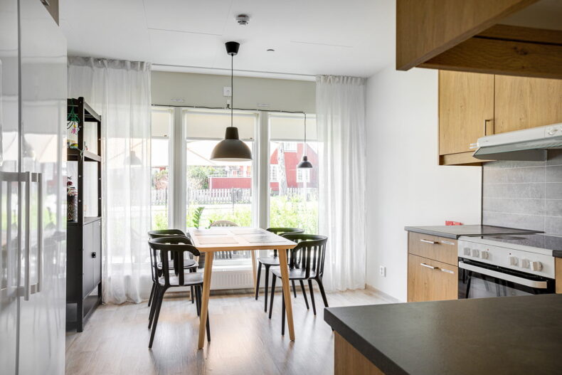 Boendets gemensamma kök med matplats framför stora ljusa fönster