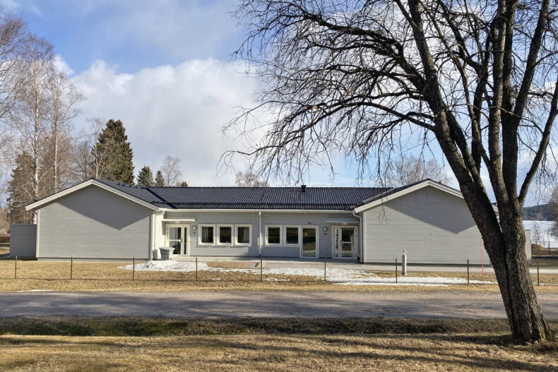 Boendets fasad med ett träd i förgrunden