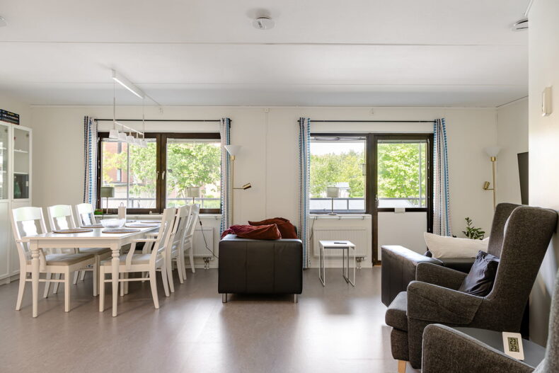 Ett gemensamt rum med matbord och soffgrupp