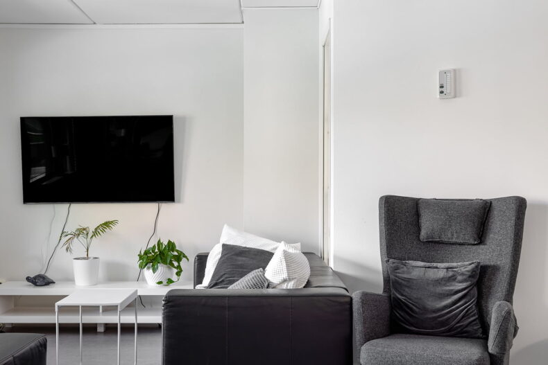 Ett gemensamt rum med soffa, fåtölj och TV