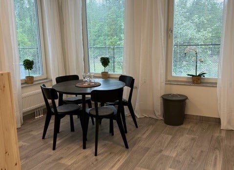 En matplats i ett hörn med stora fönster och natur utanför