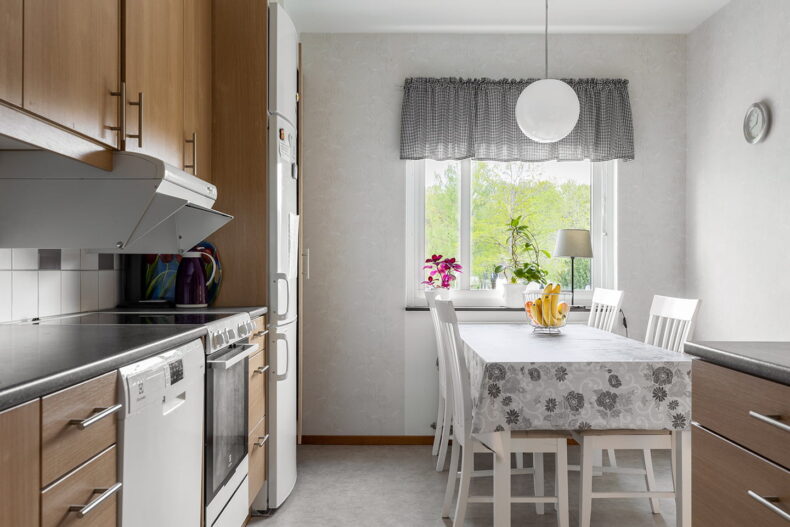 Hemtrevligt kök med matplats vid fönstret.