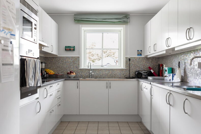 Gemensamt vitt kök med fint kakel
