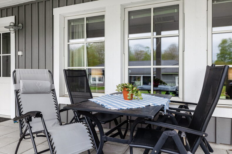 Uteplats med stolar och bord med rutig duk