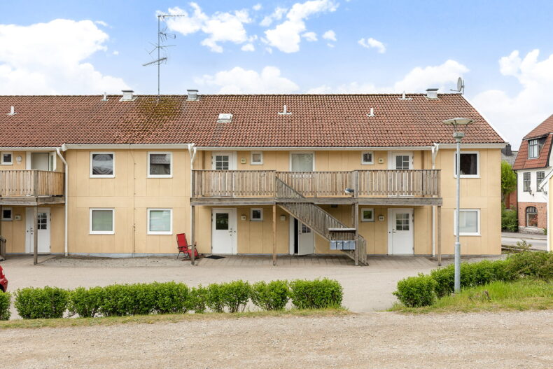Servicebostadens gula tvåvåningshus med loftgång.
