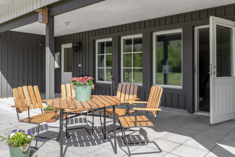 Stenlagd uteplats med bord och stolar dekorerat med fina blommor