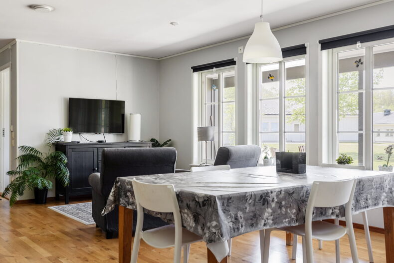 Matbord med en blommig duk, i bakgrunden är TV hörnan