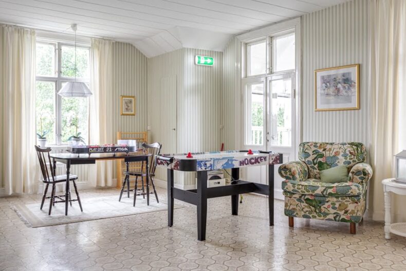 Ett ljust rum med bord för air hockey och fotbollsspel