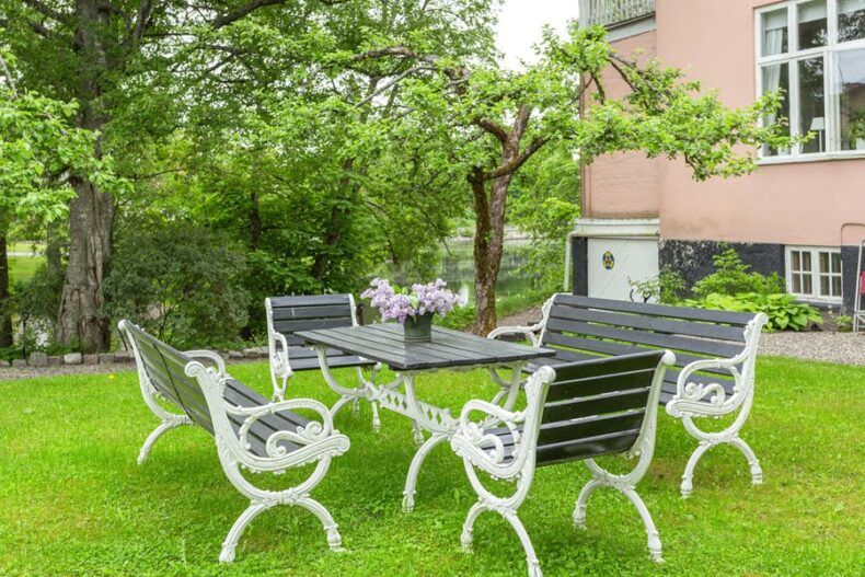 Gammaldags utemöbler på en gräsmatta bredvid boendet