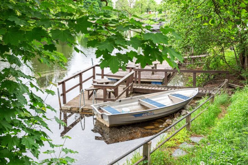 En närliggande brygga vid vattnet, med en roddbåt förtöjd bredvid en badstege