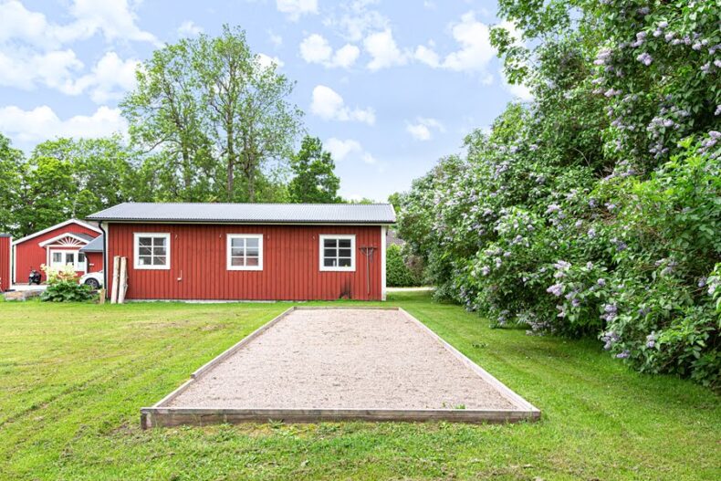 Boendets boule-bana intill en syrénhäck