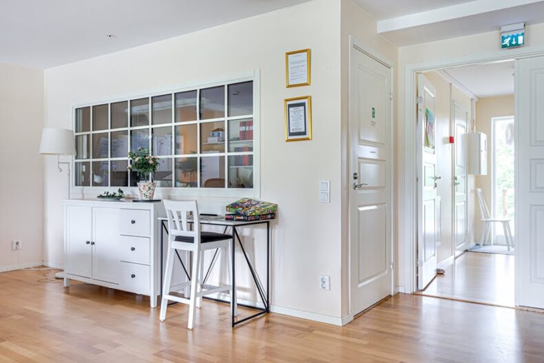 Vy från köket mot ett litet personalrum med fönster på ena väggen