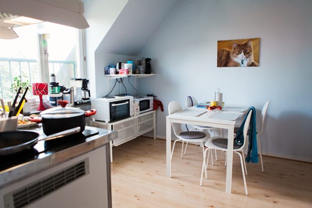 Ett ljust kök med matplats och ett foto av en katt på väggen.