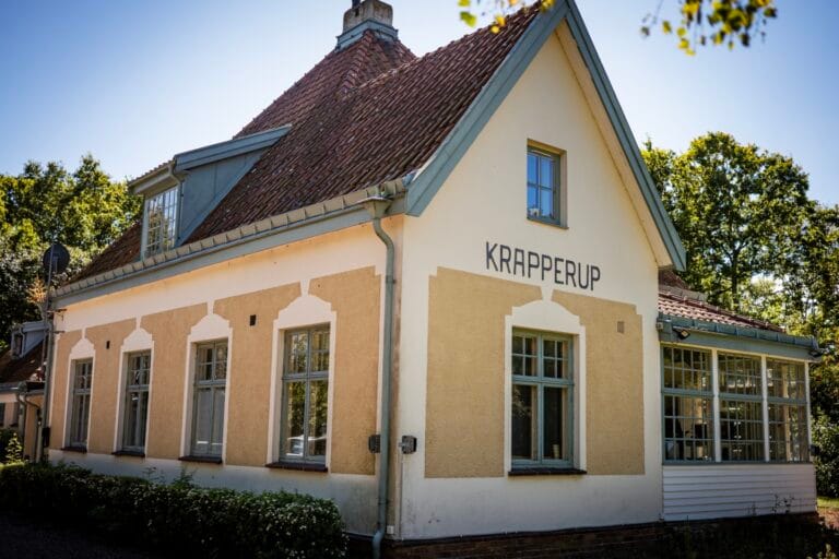 Boendets fasad, en äldre villa med stora fönster och texten "Krapperup" på ena väggen.