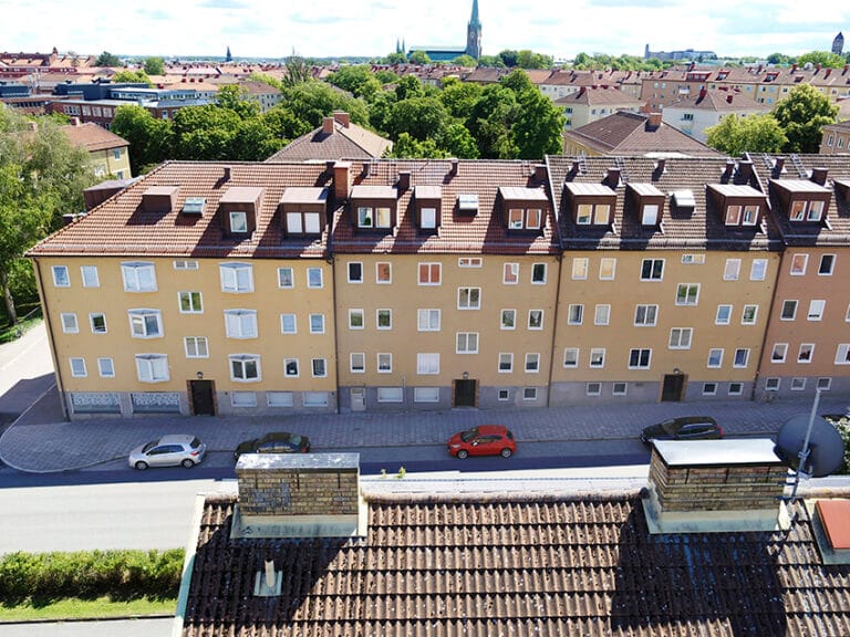 Flygfoto på verksamheten, ett gult flerfamiljshus i stadsmiljö